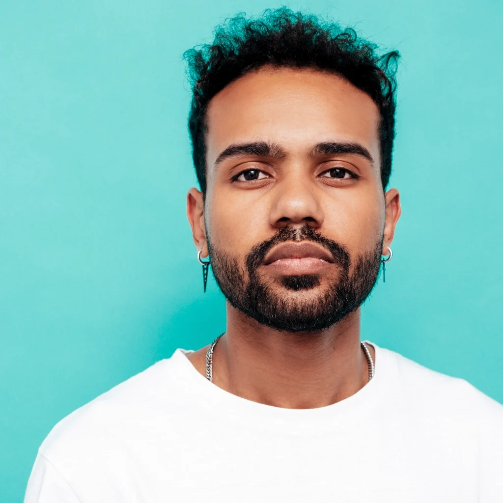 Young South Asian man looking into the camera.