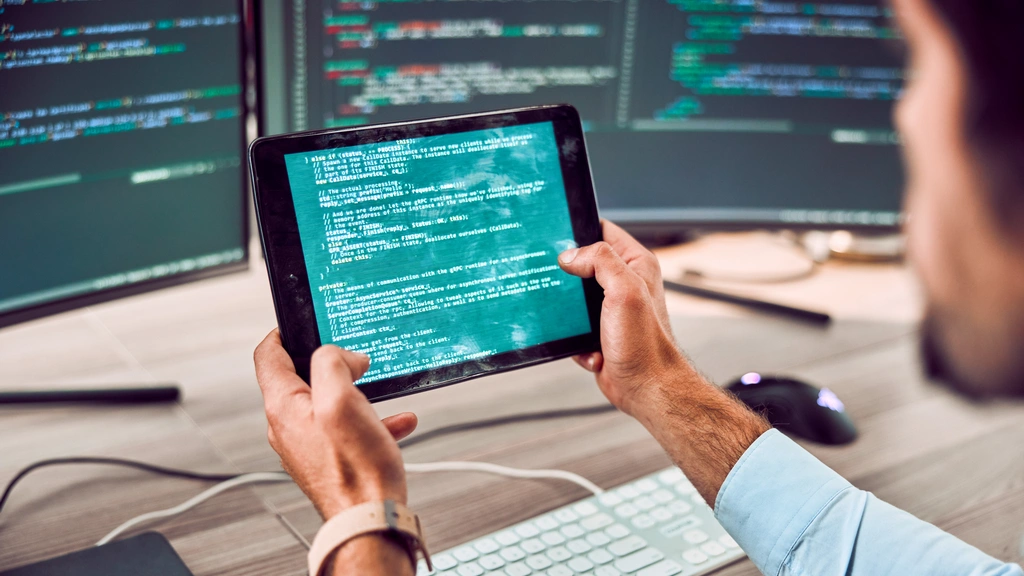 Man looking at code on a tablet.
